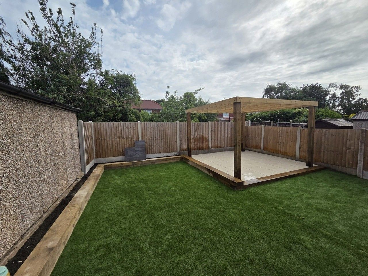 Garden with paved seating area and fencing