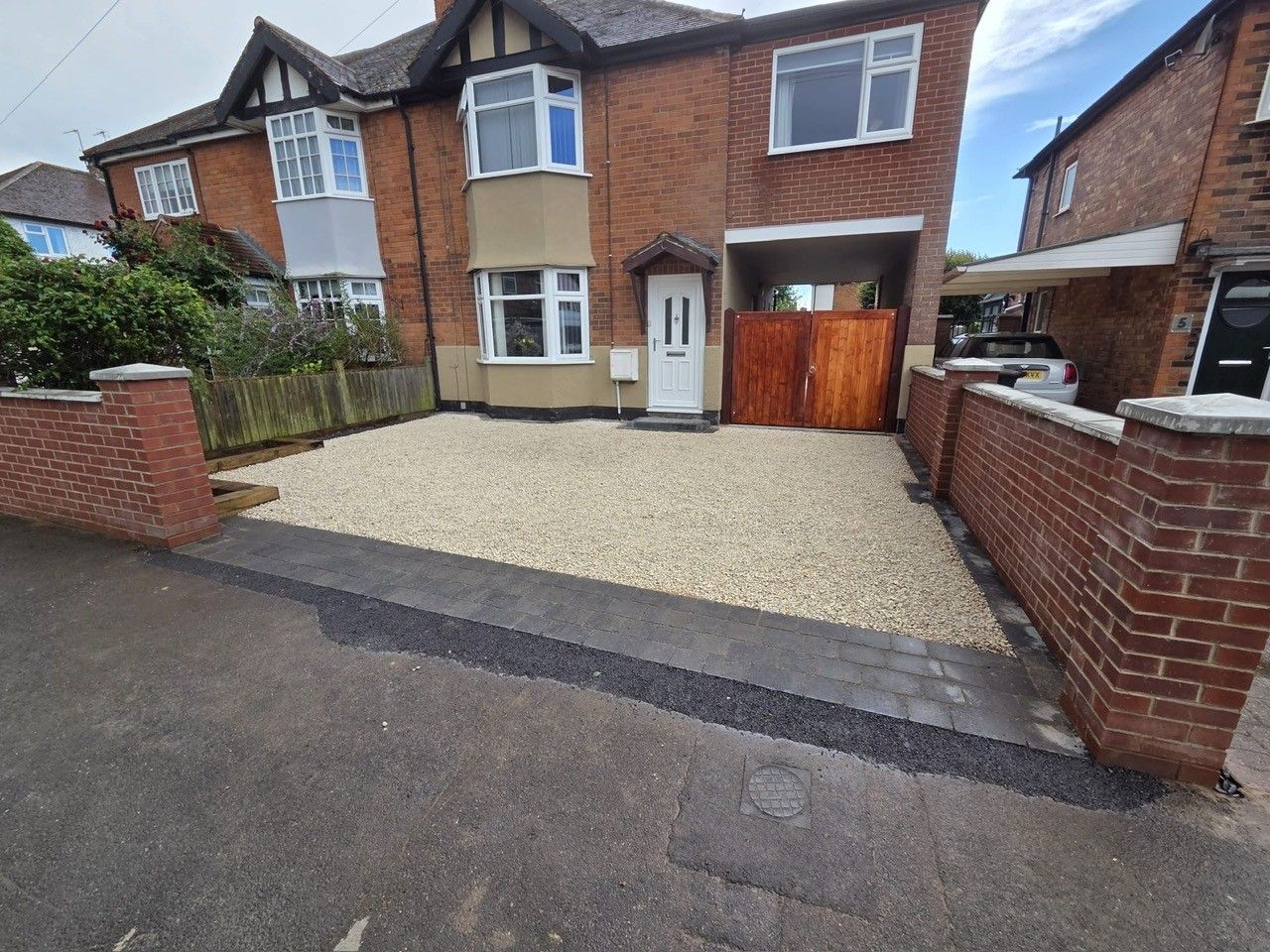 New gravel driveway with brick walls
