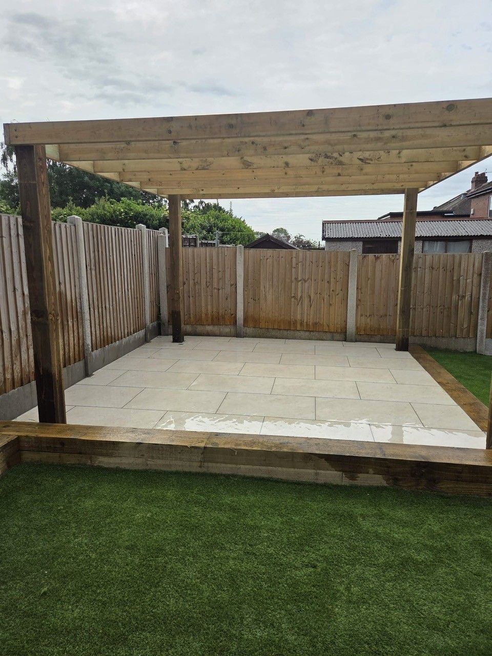 Pergola over porcelain patio with new turf